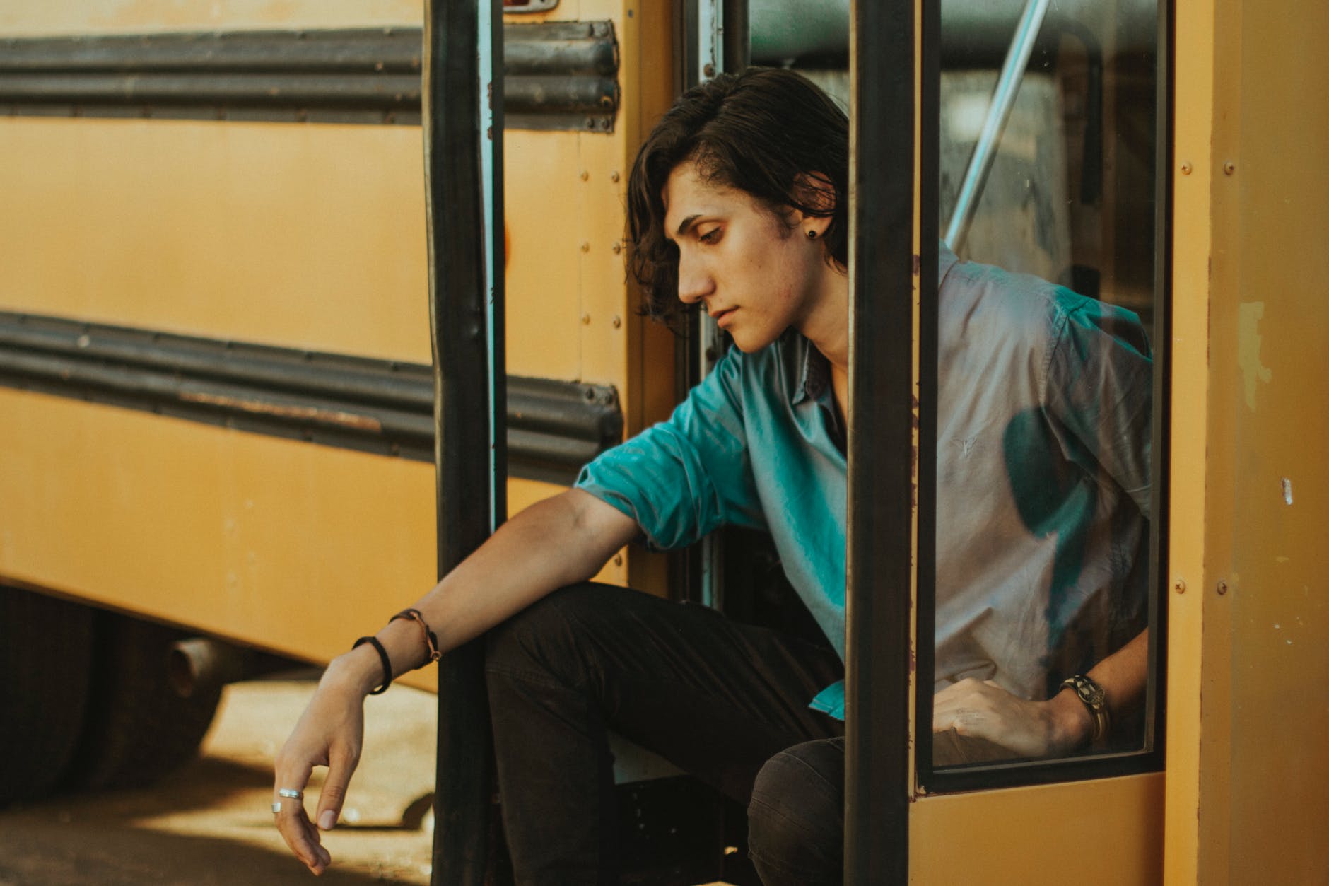 man sitting on door of school bus