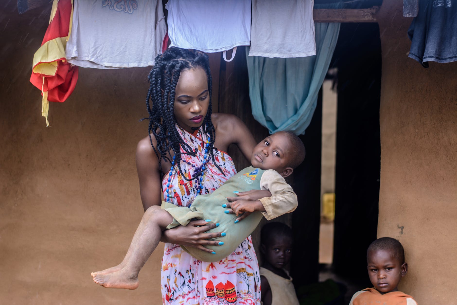 woman in multicolored halter dress carrying child