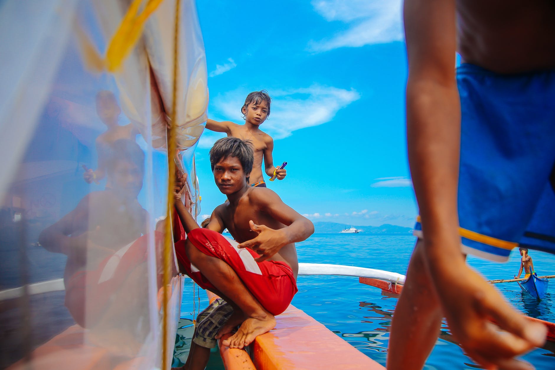 teenage boys sitting on edge of boat
